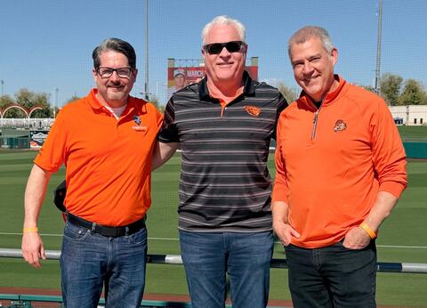 Three men wearing beaver gear smile together