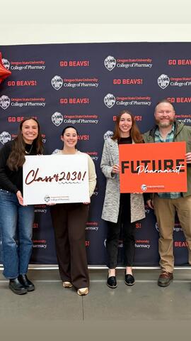 Four people stand with signs that read "Class of 2030!" and "Future Pharmacist"